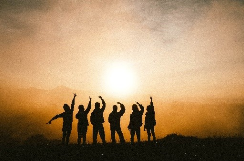 Fröhlichen Menschen winken der Sonne zu